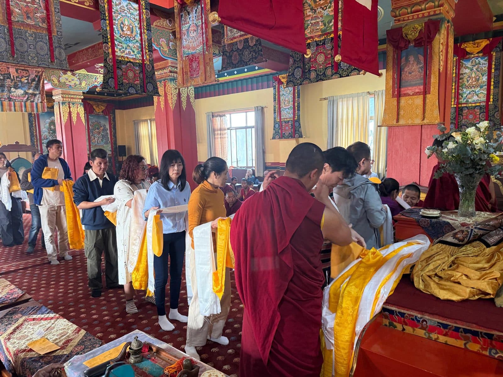 Offering khatas to the monks in the shrine hall