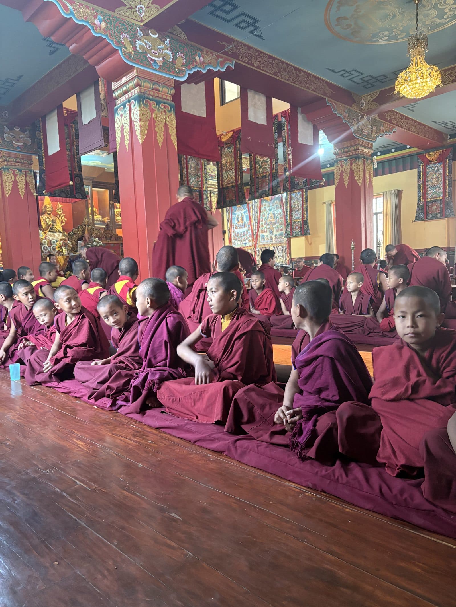 Young monks at prayer in the monastery hall